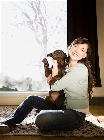 dog sitting on a window - young woman with a brown puppy Stock Photo - Premium Royalty-Free, Code: 640-06051029