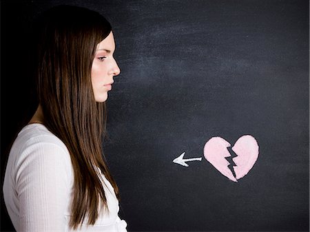 female broken heart - young woman against a chalkboard Stock Photo - Premium Royalty-Free, Code: 640-06051067