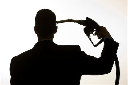 recurso natural - man holding a gas pump to his head Foto de stock - Royalty Free Premium, Número: 640-06051225