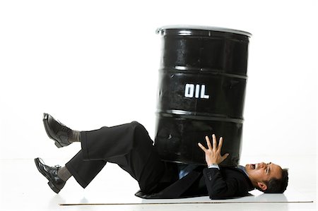 man being crushed by an oil barrel Stock Photo - Premium Royalty-Free, Code: 640-06051230