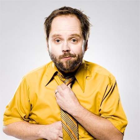 straighten - man in a yellow shirt and tie fixing his tie Stock Photo - Premium Royalty-Free, Code: 640-06051698