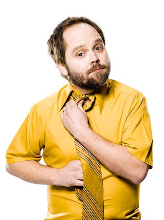 man in a yellow shirt and tie fixing his tie Stock Photo - Premium Royalty-Free, Code: 640-06051700