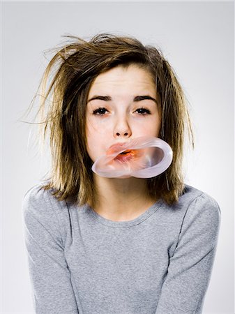 girl with a messy appearance popping a bubble gum bubble Foto de stock - Sin royalties Premium, Código: 640-06051703