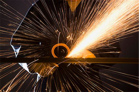 man in blue coveralls with a power grinder Stock Photo - Premium Royalty-Free, Code: 640-06051790