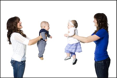 two mothers holding their babies face to face Stock Photo - Premium Royalty-Free, Code: 640-06051809