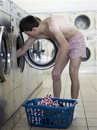 man taking off clothes at a laundromat Stock Photo - Premium Royalty-Free, Code: 640-06051902