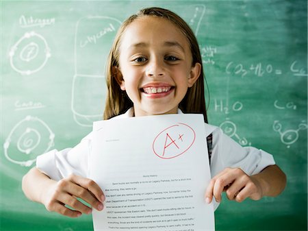 simsearch:6109-06196569,k - girl in a classroom holding up an a plus paper Foto de stock - Sin royalties Premium, Código: 640-06052175