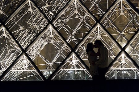 France, Paris, The Louvre, Couple kissing in front of glass pyramid Foto de stock - Royalty Free Premium, Número: 640-06963112