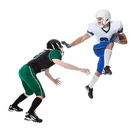 Close up of two young players of American football fighting for ball, studio shot Photographie de stock - Premium Libres de Droits, Code: 640-06963148