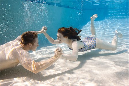 smiling women underwater - USA, Utah, Orem, Young couple under water Stock Photo - Premium Royalty-Free, Code: 640-06963295