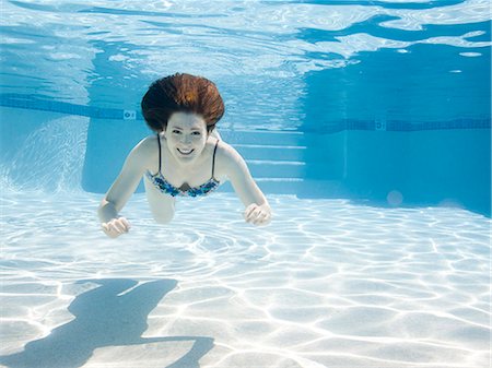 day time underwater - USA, Utah, Orem, Smiling woman swimming in swimming pool Stock Photo - Premium Royalty-Free, Code: 640-06963302