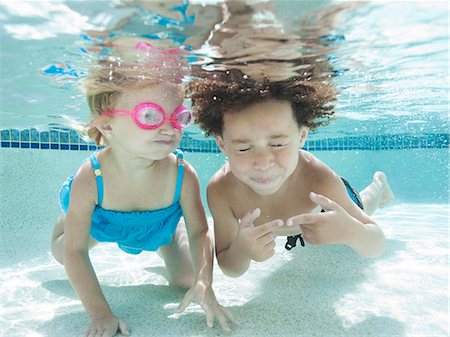 portrait of a boy underwater - USA, Utah, Orem, Boy (4-5) and girl (2-3) swimming in pool Foto de stock - Sin royalties Premium, Código: 640-06963369