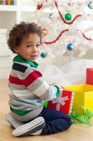 regalo de navidad - Young boy sitting under Christmas tree, opening Christmas presents Foto de stock - Sin royalties Premium, Código: 640-06963458