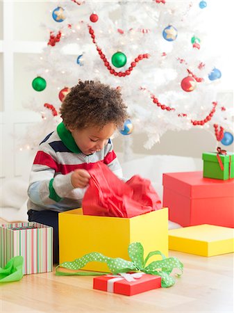 Young boy sitting under Christmas tree, opening Christmas presents Photographie de stock - Premium Libres de Droits, Code: 640-06963461