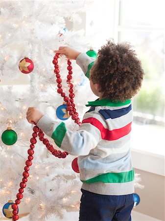 simsearch:640-06963728,k - Happy young boy decorating Christmas tree Foto de stock - Sin royalties Premium, Código: 640-06963471