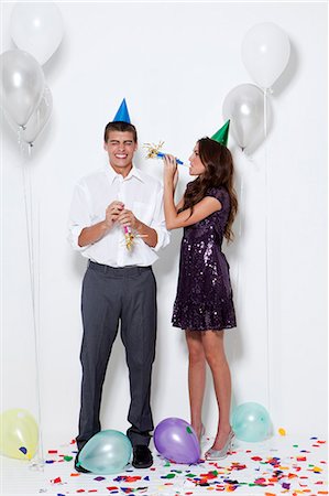 funny birthday - Young couple blowing horns at party Stock Photo - Premium Royalty-Free, Code: 640-06963491