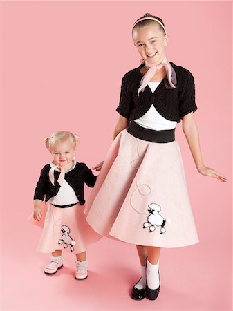 dog smile studio - Portrait of girls (12-17 months) and (10-11) in 1950s style costumes for Halloween Stock Photo - Premium Royalty-Free, Code: 640-06963581