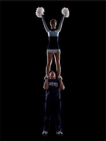 Teenage sportsman(16-17) holding aloft teenage cheerleader girl (16-17) Stock Photo - Premium Royalty-Free, Code: 640-06963615