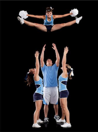 simsearch:640-06963763,k - Studio shot of cheerleaders (16-17) assisting friend during jump Photographie de stock - Premium Libres de Droits, Code: 640-06963635