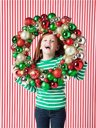 Studio portrait of girl (4-5) holding Christmas decoration Foto de stock - Sin royalties Premium, Código: 640-06963695