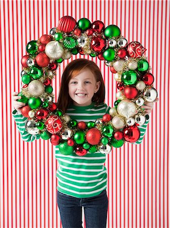 Studio portrait of girl (4-5) holding Christmas decoration Photographie de stock - Premium Libres de Droits, Code: 640-06963697