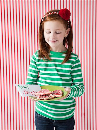 Studio portrait of girl (4-5) holding letter to Santa and cookies Stock Photo - Premium Royalty-Free, Code: 640-06963705