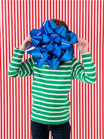 Studio shot of girl (4-5) holding large gift bow in front of face Foto de stock - Royalty Free Premium, Número: 640-06963706