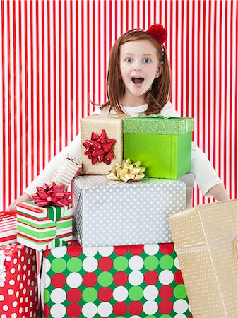 striped wrapping paper - Studio shot of girl (4-5) with stack of Christmas gifts Stock Photo - Premium Royalty-Free, Code: 640-06963711