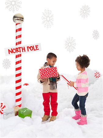 polo norte - Boy (4-5) and girl (4-5) standing next to North Pole sign Foto de stock - Sin royalties Premium, Código: 640-06963744