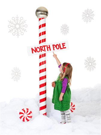 polo norte - Little girl (18-23 months) standing next to North Pole sign Foto de stock - Sin royalties Premium, Código: 640-06963756