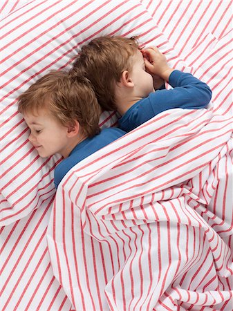 USA, Utah, Orem, Twin boys (2-3) wearing pajamas lying on bed Foto de stock - Royalty Free Premium, Número: 640-06963759