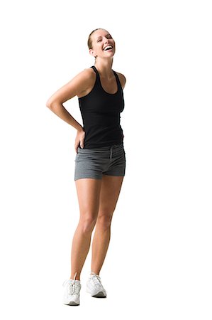 Studio portrait of young woman wearing sports clothing standing with hand on hip, smiling Stock Photo - Premium Royalty-Free, Code: 640-08088990