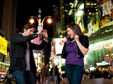 simsearch:632-02885199,k - USA, New York, New York City, Manhattan, Times Square, smiling  young couple dancing in street Foto de stock - Royalty Free Premium, Número: 640-08089029