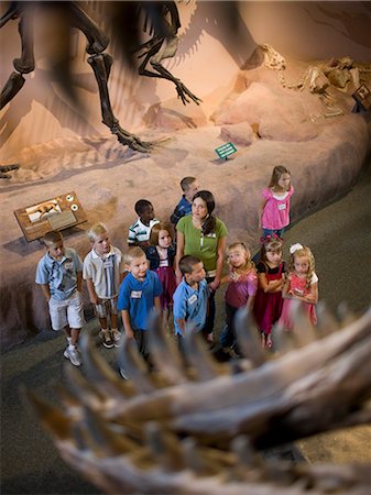 school boy standing and looking up - USA, Utah, Lehi, teacher with children (4-9) at museum Stock Photo - Premium Royalty-Free, Code: 640-08089052