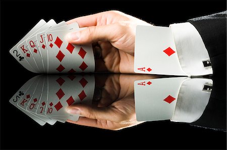 hand holding playing cards with an ace up his sleeve Stock Photo - Premium Royalty-Free, Code: 640-08089160