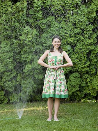 woman in a dress standing in the sprinklers Stock Photo - Premium Royalty-Free, Code: 640-08089612