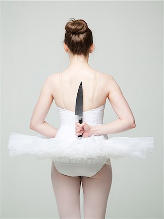 Studio shot of ballet dancer holding knife behind back Stock Photo - Premium Royalty-Free, Code: 640-08546088