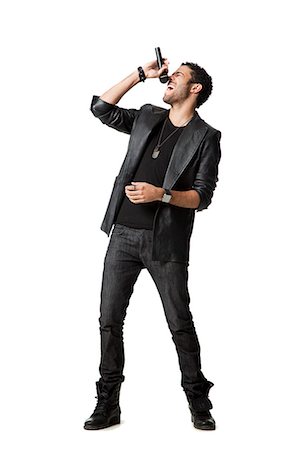 performer portrait white background - Man standing in studio singing into microphone Stock Photo - Premium Royalty-Free, Code: 640-08546163