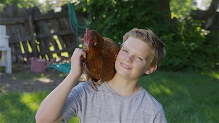 streicheln - High angle portrait of smiling boy petting rooster on shoulder in backyard Stockbilder - Premium RF Lizenzfrei, Bildnummer: 640-09013338