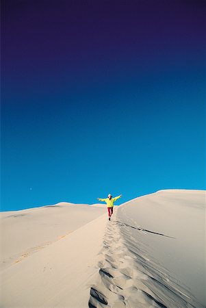 simsearch:400-04034980,k - Person walking on a sand dune Foto de stock - Royalty Free Premium, Número: 640-01348437