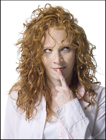 Close-up of a young woman with her finger on her lips Stock Photo - Premium Royalty-Free, Code: 640-01348595