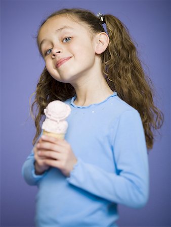Close-up of a girl holding an ice cream cone Stock Photo - Premium Royalty-Free, Code: 640-01348605