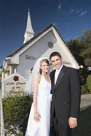 simsearch:640-01351306,k - Portrait d'un couple de jeunes mariés, debout devant une chapelle et souriant Photographie de stock - Premium Libres de Droits, Code: 640-01348711