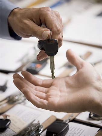 Close-up of a person giving a car key to another person Stock Photo - Premium Royalty-Free, Code: 640-01348752