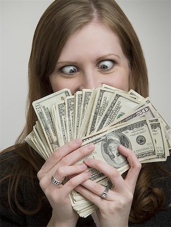 fanned out - Close-up of a young woman looking at American paper currency Stock Photo - Premium Royalty-Free, Code: 640-01349027