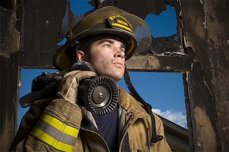firefighter close - Low angle view of a firefighter holding a fire hose Stock Photo - Premium Royalty-Free, Code: 640-01349050
