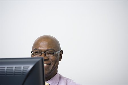 Close-up of a businessman using a computer and smiling Stock Photo - Premium Royalty-Free, Code: 640-01349082