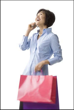 Mid adult woman holding shopping bags and talking on a cell phone Stock Photo - Premium Royalty-Free, Code: 640-01349144