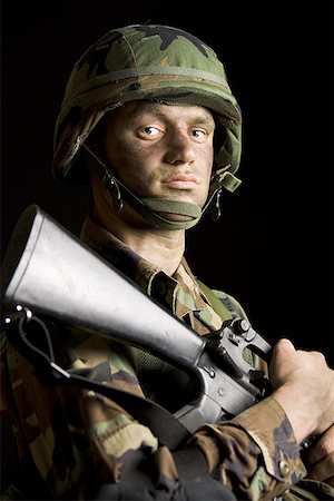 Portrait of a soldier holding a rifle Foto de stock - Sin royalties Premium, Código: 640-01349146