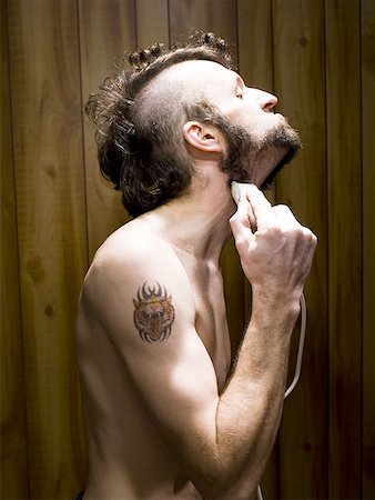 face man tatoo - Man with tattoo shaving beard Stock Photo - Premium Royalty-Free, Code: 640-01349313